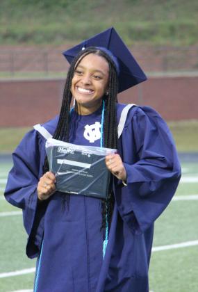 A graduate smiles as she presents her diploma during the 2026 White County High School graduation ceremony. CARLY HENDERSON/WCN