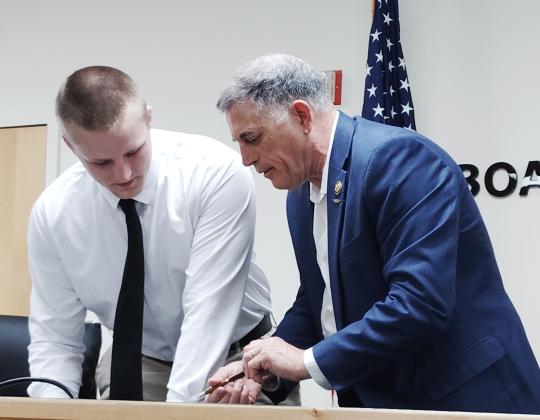 White County High School graduate Bryson Howe, left, prepares to sign his commitment pledge during a signing ceremony on June 18. Howe received a congressional appointment to the U.S. Naval Academy from Congressman Andrew Clyde, right.