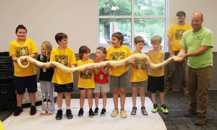 Local Cub Scout Pack 140 kicked off its annual Twilight Camp this week. Scouts from kindergarten through fifth grade enjoyed a special visit from the North Georgia Wildlife Park where they met several fascinating animals up close. From left are Xander Wooley, Olivia Parsons, Kade Gibson, Joann Wooley, Malachai, Bryce Willis, Weston Thomas, Jonas Wade, Matt Wooley and North Georgia Wildlife Park animal handler Tom Bennett. (Photo by Kim Wooley)