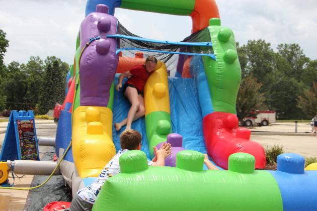 A cadet slides down an inflatable water slide during the White County Junior Law Enforcement Academy. The program includes physical training and team-building activities designed to introduce students to careers in law enforcement and public safety. PHOTOS BY CARLY HENDERSON/WCN