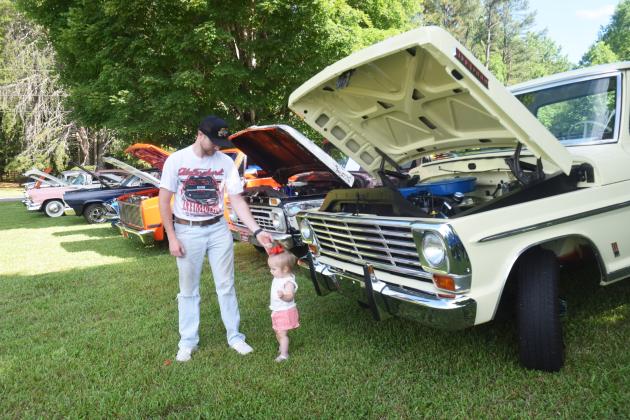 Cleveland resident Jason Ward and daughter Callie, age 1, look at classic cars during Zion Interdenominational Church's annual car show on June 13.