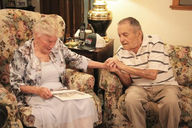 Monique Souris becomes emotional while looking at a wartime-era photograph from Lorient as Andy Negra holds her hand during their meeting. PHOTOS BY CARLY HENDERSON/WCN