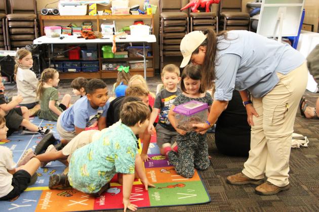 Kathy Church introduces Tina the tarantula to children at the Cleveland Library.