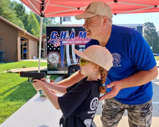 Sgt. Daren Welborn shows Graylee Schrader how to properly handle and discharge a firearm, or pellet gun in this case, at the 2026 Junior Law Enforcement Academy. PHOTOS BY ERIN ETRIS/WCN