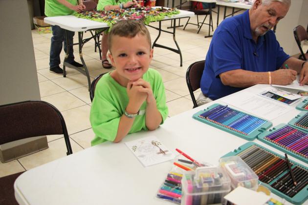 Atticus Miles writes an encouragement card to be included in a comfort backpack for a child entering foster care during the Love Your Neighbor event at Helen First Baptist Church on July 11. PHOTOS BY CARLY HENDERSON/WCN