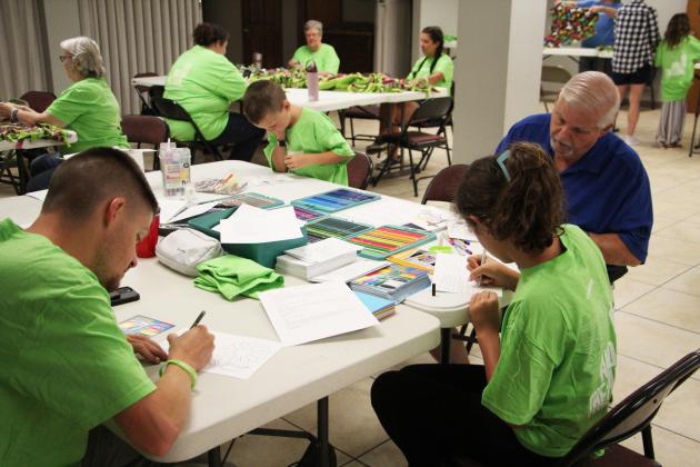 From left, Evan Miles, Atticus Miles, Riley Miles and Harry Warren write and decorate encouragement cards to be included in comfort backpacks for children entering foster care during the Love Your Neighbor event at Helen First Baptist Church on July 11.