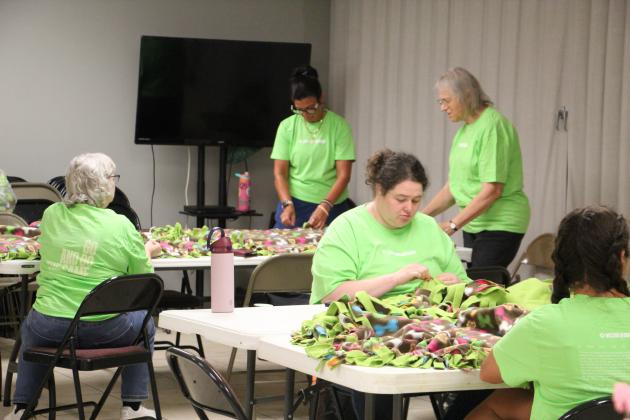 From left, Robyn Addison, Sharon Lee, Catie Lee, Becky Cooley and Brittani Miles make fleece blankets for comfort backpacks during the Love Your Neighbor event at Helen First Baptist Church on July 11.