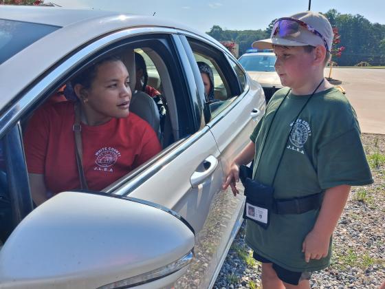 JLEA attendee Brayden Martin keeps his hand at his weapon as he approaches a vehicle of unruly gang members played by middle schooler Mary Brenton and friends as Officer Shawn Blinn of the White County Sheriff's Office helps Martin check for proper identification.