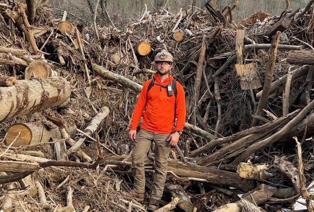 White County resident Michael Foley stands among storm debris during one of more than 60 helicopter missions he completed in western North Carolina following Hurricane Helene. Foley’s experiences during the missions later became the inspiration for “Scars on the Mountain,” a documentary about the storm’s impact on Yancey County residents. SUBMITTED PHOTO
