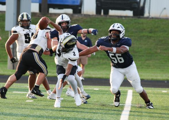 WCHS defensive linemen Sam Harkins, right, and Josiah Williams track down East Hall quarterback Jody Dudley during the Warriors' 49-14 win last weelk at Warrior Stadium. STACI SULHOFF/WCN