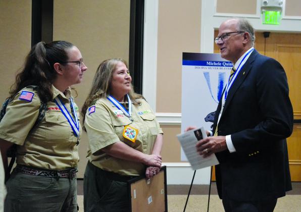 Council President Stewart Swanson (right) congratulates Michele Quintal (center) after the ceremony with Jessica Barnett. Barnett is the Scoutmaster for Troop 5231 in Snellville.