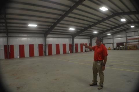 Mountain Education Charter High School Assistant Superintendent Tracy Sanford points to the back wall of the system’s new transportation and storage facility, where new bay doors will be installed. The building is the former site of Sautee Hard Cider on Helen Highway. (Photo/Wayne Hardy)