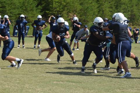 Jaquez Williams, No. 52, opens up a running lane for Cory Ezzard, No. 22, during an 11-on-11 period Tuesday morning. (Photos/Mark Turner)