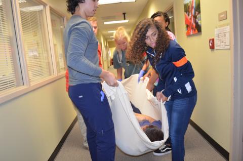 From left, Joshua Thereur, Caleb Johnston, Taylor Brown, Amaya Cartwright and Brittany Linley lift Ethan Conners as they prepare to carry him down the stairs to be transported. (Photo/Stephanie Hill)
