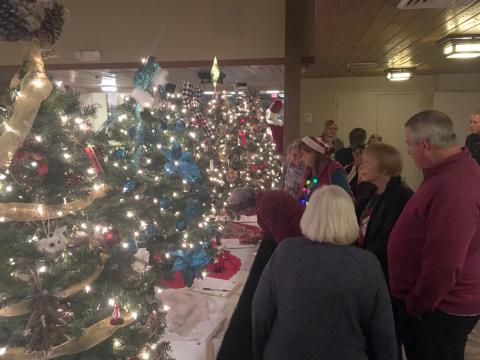 Guests had the opportunity to make last-minute bids on Christmas trees, sponsored by community businesses and organizations. (Photo/Wayne Hardy)