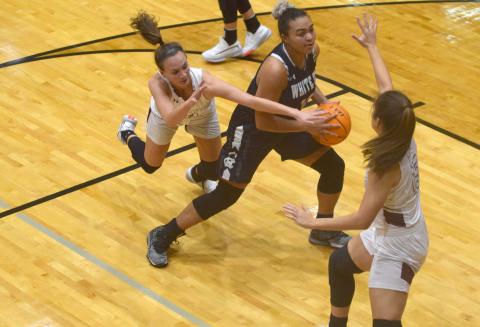 Dasha Cannon works in the lane between two defenders during Tuesday night's win over Chestatee. Cannon, a junior, was honored during the game for going over the 1,000-point total in her high school career. (Photo/Mark Turner)