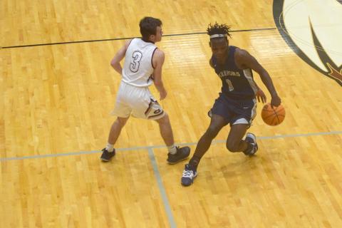 Silas Mulligan uses a behind-the-back dribble to get out of trouble during the region game. (Photo/Mark Turner)