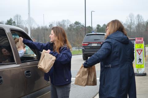 White County Schools Director of Student Accountability Jennifer King and Superintendent Dr. Laurie Burkett brought meals to a car in the drive-thru for a student feeding program, which is in place while schools are closed. (Photo/Stephanie Hill)
