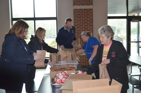 From left, White County School Superintendent Dr. Laurie Burkett, Director of School Improvement Cindy Free, White County Middle School Assistant Principal Lloyd Collins, WCMS school nutrition manager Linda Parker, and Rita Payne with school nutrition packed meals for the first day of pick-up at White County Middle School on March 16. (Photo/Stephanie Hill)