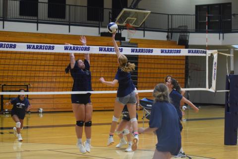 Claire Beckman, right, tips a ball at the net while Camryn Dorsey goes up for the block during practice Wednesday morning at the WCHS gym. (Photo/Mark Turner)