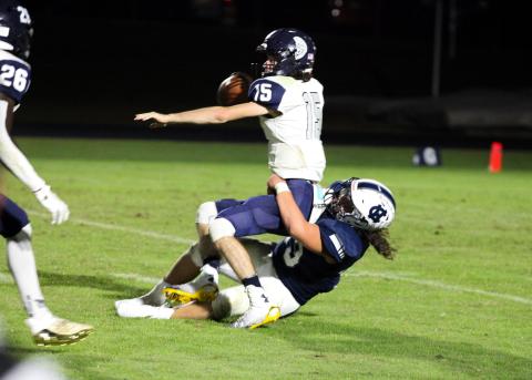 White County's Dylan Archer wrestles West Hall quarterback Clayton Jenkins to the ground for a 9-yard loss during the Warriors' 35-0 win over the Spartans last Friday in Cleveland. (Photo/Staci Sulhoff)