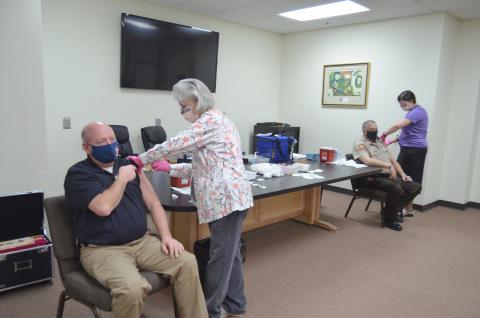 The White County Health Department held a COVID-19 vaccine clinic at the county administration building Friday, Jan. 8, for healthcare workers, first responders, firefighters and law enforcement. Shown from left are White County Public Safety Director David Murphy getting a COVID-19 vaccine from White County Health Department Nurse Manager Cindy King and White County Sheriff’s Office Deputy John Albino getting one from Health Department nurse Rebekah Withrow. (Photo/Wayne Hardy)