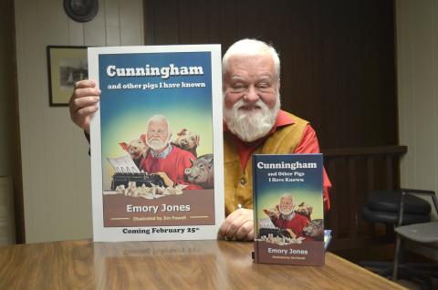 Emory Jones holds a poster featuring his book, Cunningham and Other Pigs I Have Known. (Photo/Wayne Hardy)