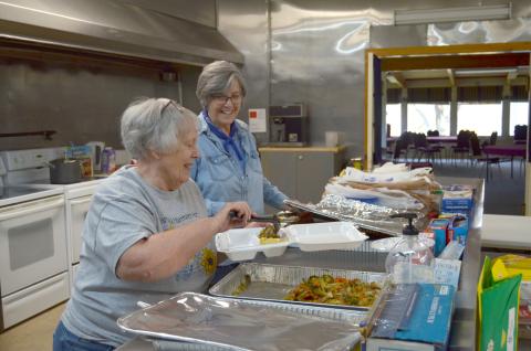 Judy Winski, left, and Melody Thomason prepare a meal to go during First Presbyterian Church of Cleveland’s inaugural First Lunch Day event on April 5. (Photo/Wayne Hardy)