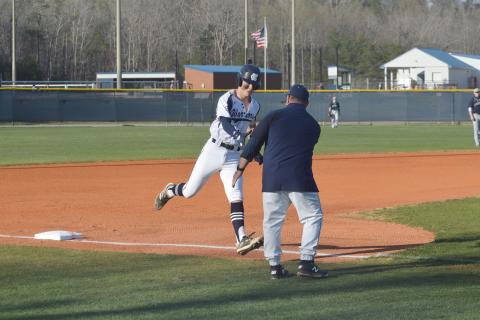 J. Ben Haynes is congratulated at third base by head coach Jim Waits after hitting a 2-run home run in the the first inning of the region win Tuesday over West Hall. (Photo/Mark Turner)