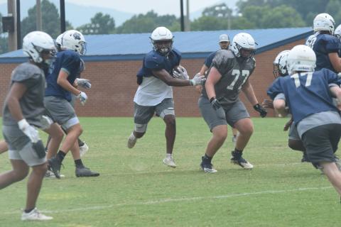 Zion McMullen, left, finds some running room off a block from Cameron Godfrey during Tuesday's practice session. The Warriors scrimmage East Forsyth next Friday night. (Photo/Mark Turner)