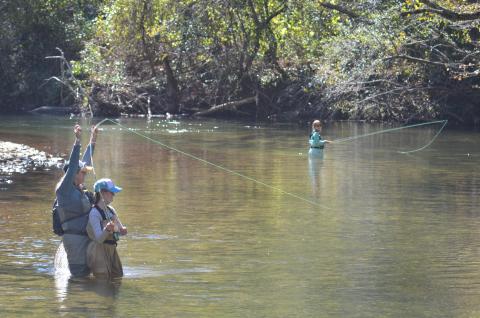 Instructor Megan Nellen celebrates as Molly Colliver hooks a fish. Natalie Smith is shown in background. (Photo/Wayne Hardy)