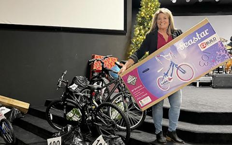 Cheryl Kennedy, associate pastor at The Bridge Church, holds one of the bicycles among the many gifts that have been donated for Family Connections’ White Christmas effort. The toys are labeled by families that have been adopted in this effort to provide Christmas to struggling families this year. Volunteers from around the county have worked in this effort. (Photo/Linda Erbele)