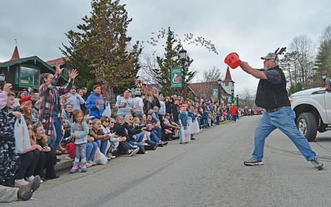 Matthew Akins of the American Red Cross tosses a bucketful of lollipops to the crowd gathered to watch Helen’s Annual Christmas Parade Saturday. (Photo/Samantha Sinclair)