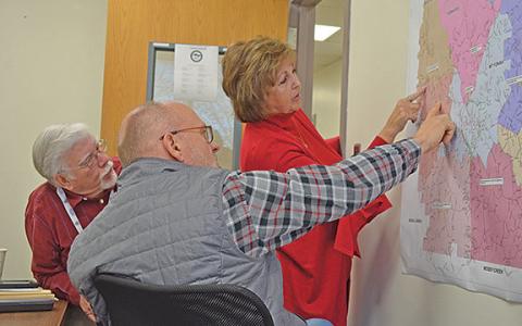 White County Board of Elections and Registration members Mike Mays, Todd Marks and Louise Nix take a closer look at the precinct map to find potential polling place locations. (Photo/Samantha Sinclair)