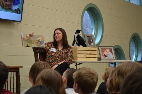 Author Laurel Hamby reads her book, Kiki Comes Home, to fourth and fifth grade students at Mt. Yonah Elementary School. Beside her is a stuffed cat that looks like Kiki, and photos of the real Kiki. (Photo/Samantha Sinclair)