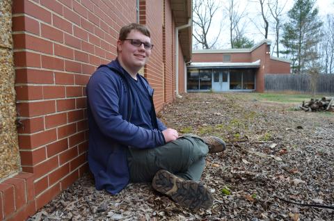 Seth Grindle, Mountain Education Charter School’s STAR Student, sits in the flower bed that he plans to clean up this spring for his Eagle Scout project. (Photo/Samantha Sinclair)