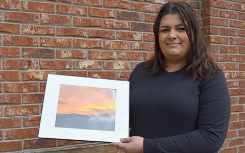 Constance Rehm holds a photo of the full image that won the Scoop cover contest. (Photo/Samantha Sinclair)