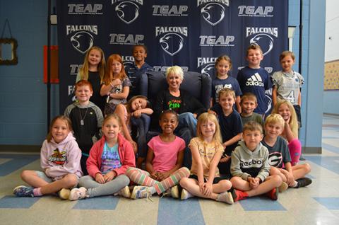 Kelli Usher is surrounded by her last class of students in front of the photo back drop at Tesnatee Gap Elementary School. (Photo/Samantha Sinclair)