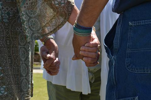 Gloria Hughes, Kim Fletter and Hal Miller join hands as they pray for each other during National Day of Prayer at Freedom Park. (Photo/Samantha Sinclair)