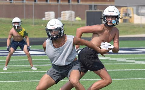 WCHS linebacker Jon Scott, left, covers John Phillips during Tuesday's workout at Warrior Stadium.  (Photo/Mark Turner)