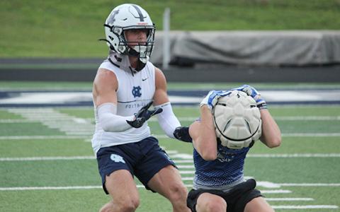 WCHS cornerback Caysen Duvall, left, closes in on a Fannin County receiver during the team's combined practice Wednesday morning at Warrior Stadium. (Photo/Mark Turner)