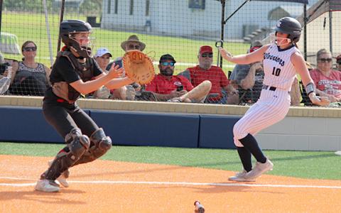 Kate Sartain, right, scores a run on a close play at the plate during the opening game over Stephens County.