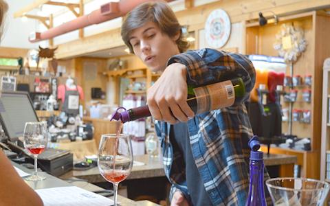 Tristan Harris pours a sample of Concord, a sweet wine from Habersham Winery, during a wine tasting last week. (Photo/Samantha Sinclair)