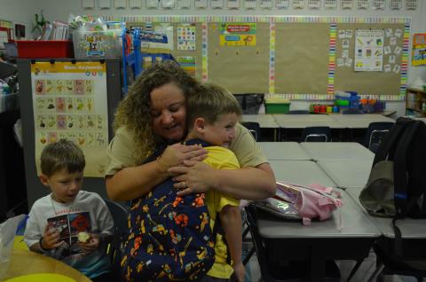 Tesnatee Gap First Grader Fischer Miller gives Suzanne Grisham a hug while stopping in his former kindergarten teacher’s classroom on the way to his class on the first day of school. (Photo/Samantha Sinclair)