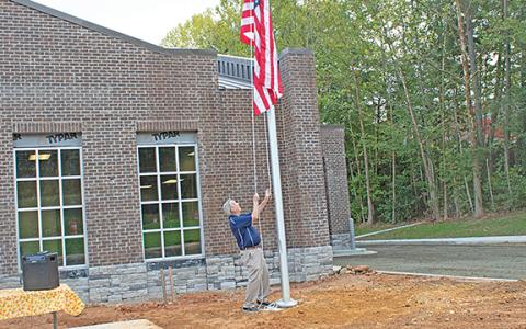 Commissioner Terry Goodger raises the American flag in remembrance of the 9/11 attacks. (Photo/Noah Johnson)