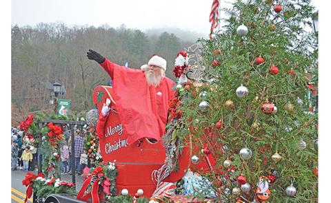 Santa, wearing a rain poncho, waves to the crowd at the center of town during Helen’s Annual Christmas Parade on Saturday. Look for more photos on Page 14A. (Photo/Samantha Sinclair)