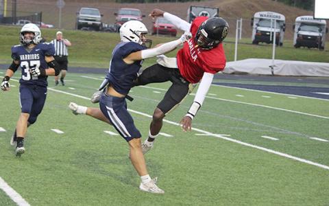 Warrior linebacker Jon Scott upends East Hall quarterback Jarmarcus Harrison. (Photo/Mark Turner)
