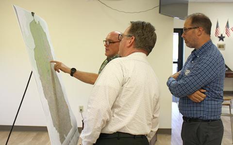 John Sell and Joe Rothwell listen to Tom O’Bryant explain a portion of the map of proposed trails. (Photo/Eric Tiongson)