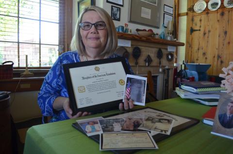 Marcie Gunter Caudell holds her certificate of membership in Daughters of American Revolution, along with a photo of the grave site of Aaron Boggs, her patriot. (Photo/Samantha Sinclair)