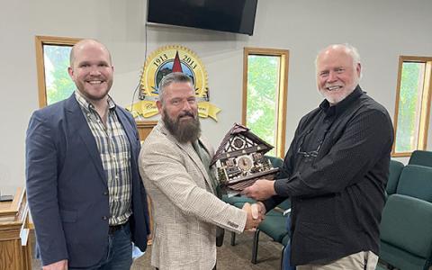Rob Ellis and Thomas Clark pose with Mayor Steve Fowler after gifting the city of Helen a limited edition cuckoo clock. (Photo/Eric Tiongson)
